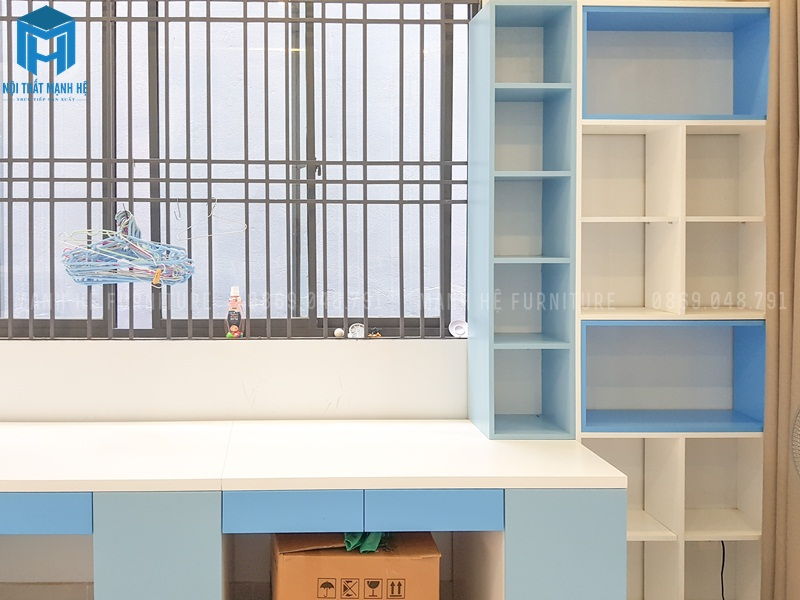 Khu học tập cho bé với chiếc bàn dài và kệ sách thiết kế tận dụng khoảng trống