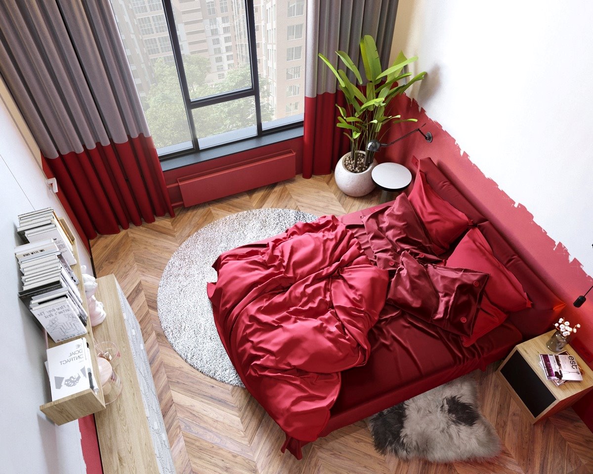 Chiếc giường cùng bộ chăn ga màu đỏ nổi bật chính giữa căn phòng ngủ