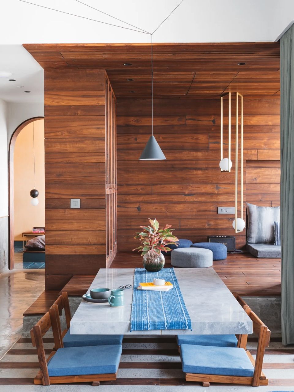 Không gian bếp thêm phong vị với bàn ăn ngồi bệt mặt đá kết hợp với ghế gỗ đệm xanh