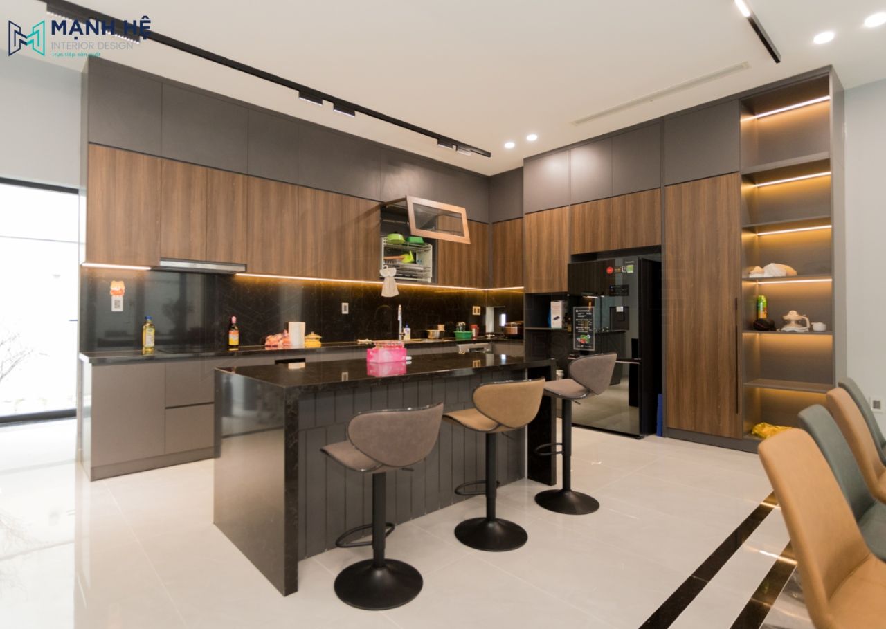 Hệ tủ bếp được thiết kế cao đụng trần sử dụng tông gỗ kết hợp với màu đen huyền bí hiện đại