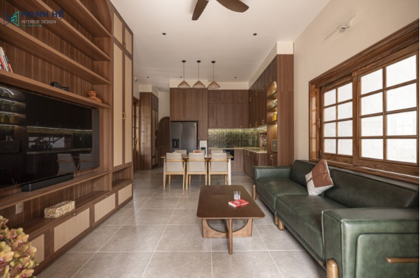 phòng khách liền bếp phong cách japandi bằng gỗ tông màu trầm với sofa da xanh lá