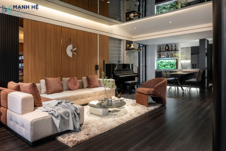 Ghế sofa chữ L kết hợp bàn trà mặt kính được đặt chính giữa phòng khách sang trọng, hiện đại