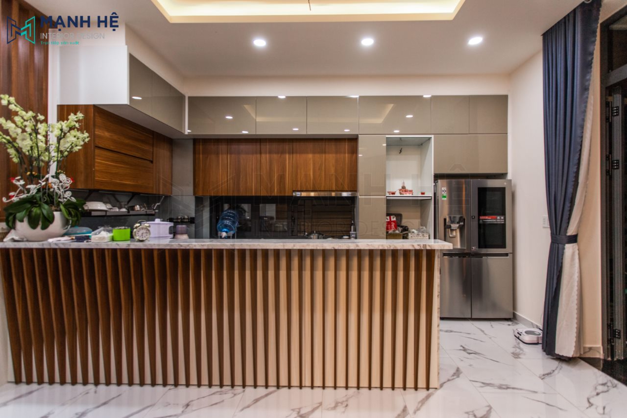 Thi Cong Noi That Nha Pho Tủ bếp trên vân màu gỗ tự nhiên, tủ bếp dưới ốp nan gỗ vô cùng sang trọng cho bạn một không gian vừa ấm áp vừa hiện đại