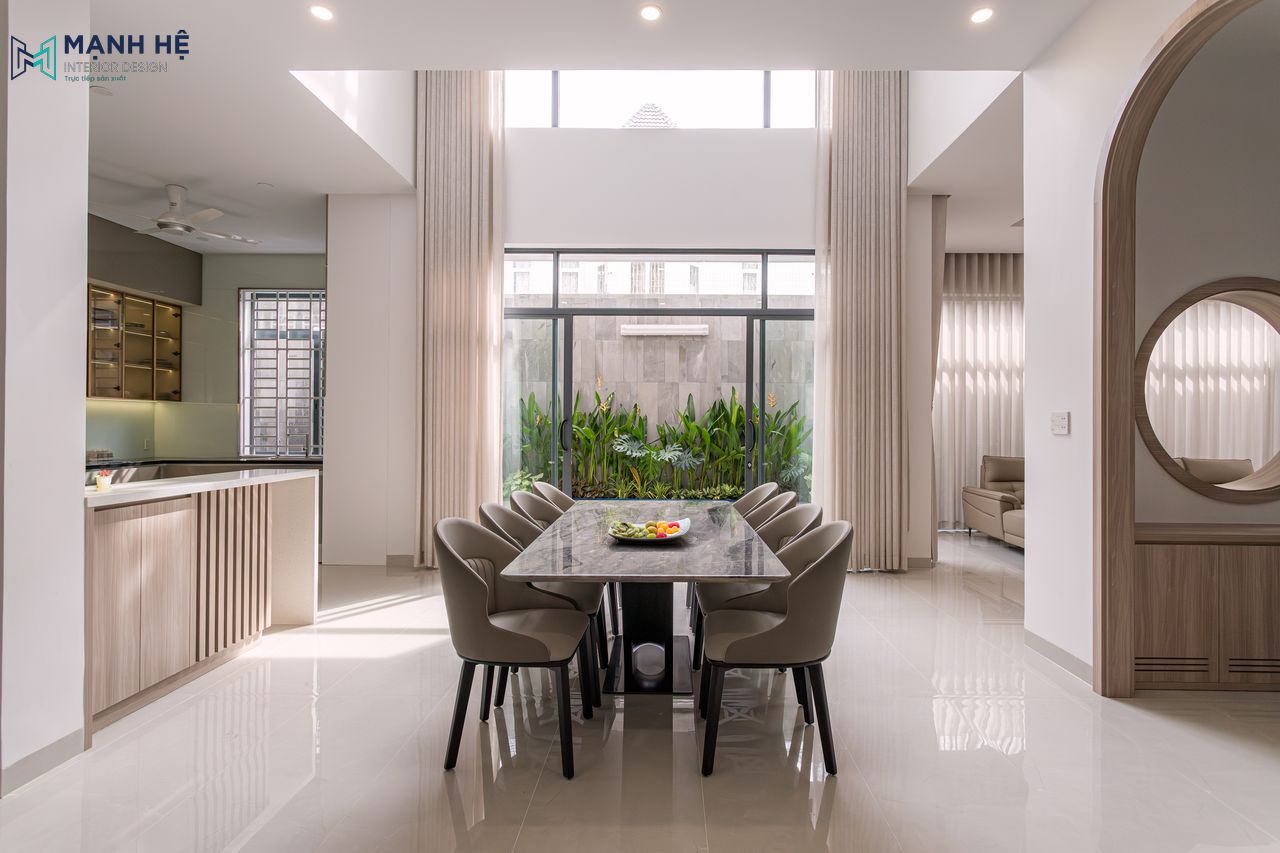 Bộ bàn ăn 8 ghế bọc da cao cấp được bố trí gọn gàng nằm giữa phòng bếp và khách, mặt bàn ăn làm từ đá marble sang trọng