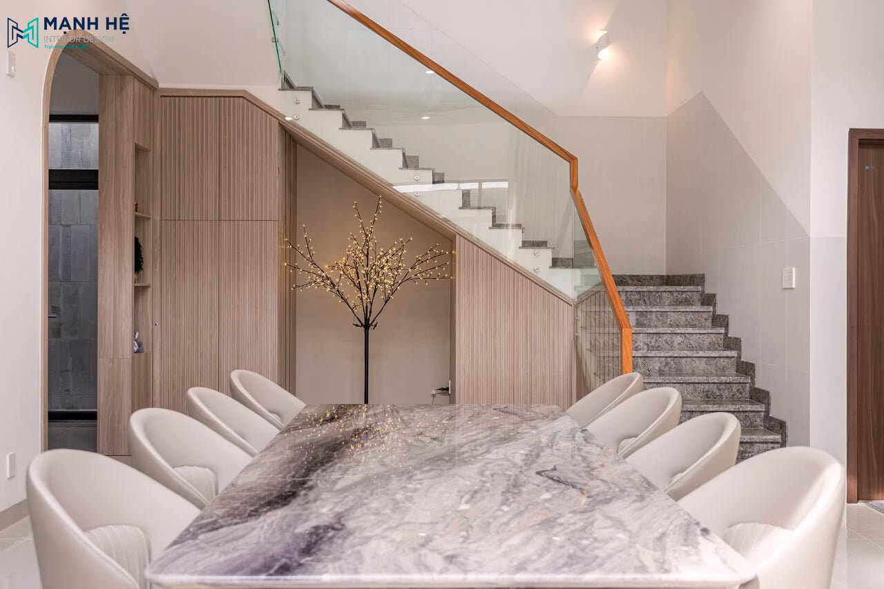 Tận dụng không gian trống dưới gầm cầu thang để trang trí cây cảnh cho không gian thêm phần sinh động, kết hợp thêm kệ tủ nhỏ decor vật dụng