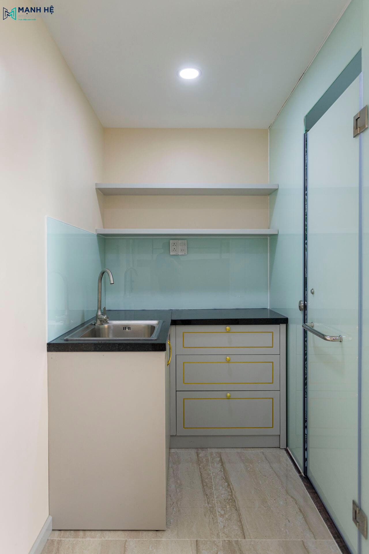 Thi công tủ bếp chữ L nhỏ gọn, tiện nghi với nhiều ngăn kéo chứa đựng, mặt bếp được ốp đá màu đen sang trọng dễ dàng lau chùi vệ sinh