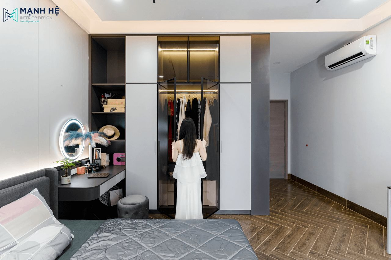 Hệ tủ quần áo kịch trần được thi công sơn màu xám đen và cánh kính sang trọng, tích hợp thêm đèn led âm tủ thông minh