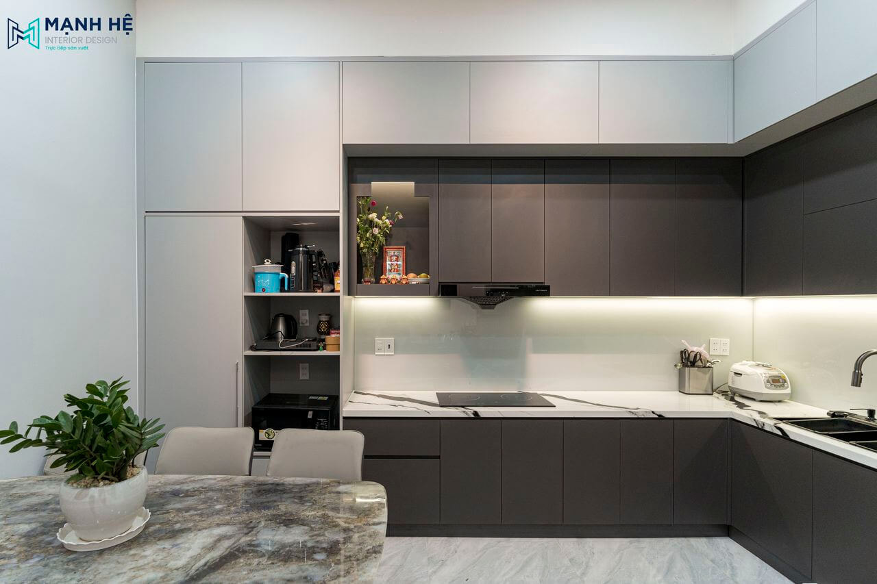 Thi công tủ bếp gỗ công nghiệp kịch trần có tích hợp bàn thờ nhỏ tinh tế, mặt bếp ốp đá marble sang trọng