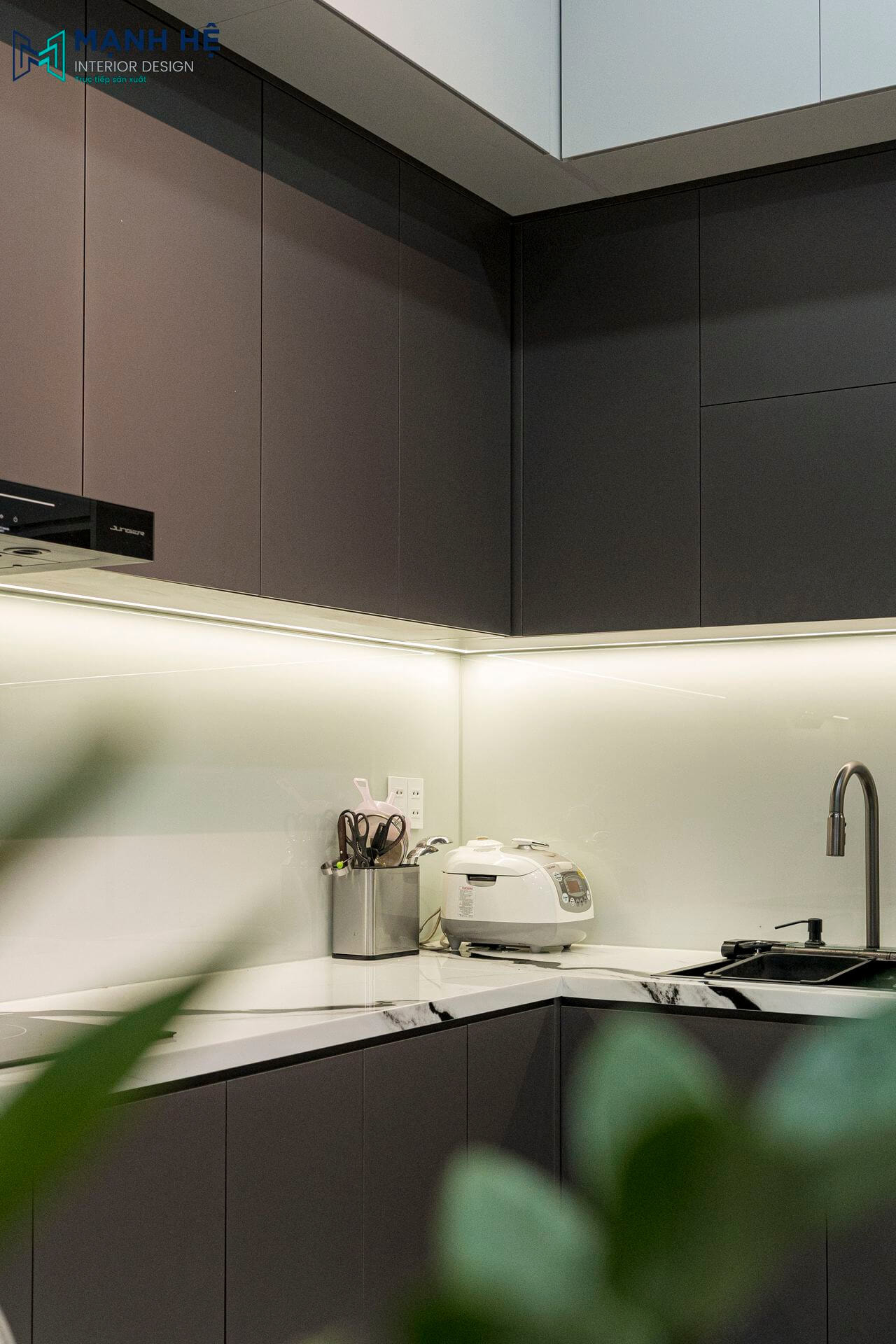 Thi công căn bếp sang trọng khi ốp bếp mặt kính tích hợp chạy đèn âm tủ hiện đại, mặt bắt ốp đá marble sáng bóng dễ lau chùi