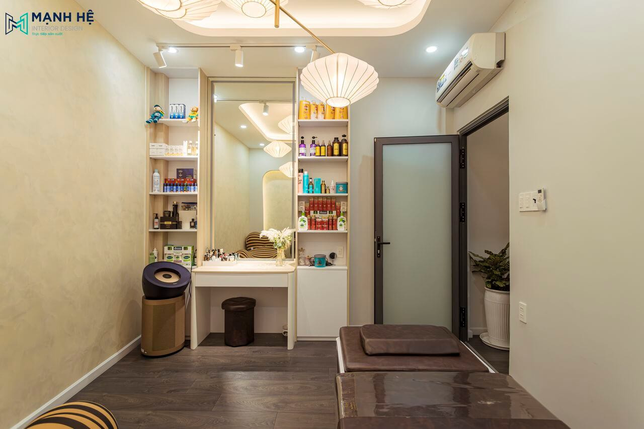 Bàn trang điểm tích hợp kệ tủ lớn đựng mỹ phẩm 2 bên giúp gia chủ tha hồ cất giữ đồ dùng, trần thạch cao giật cấp nổi bật với hệ đèn chùm trang trí tinh xảo.