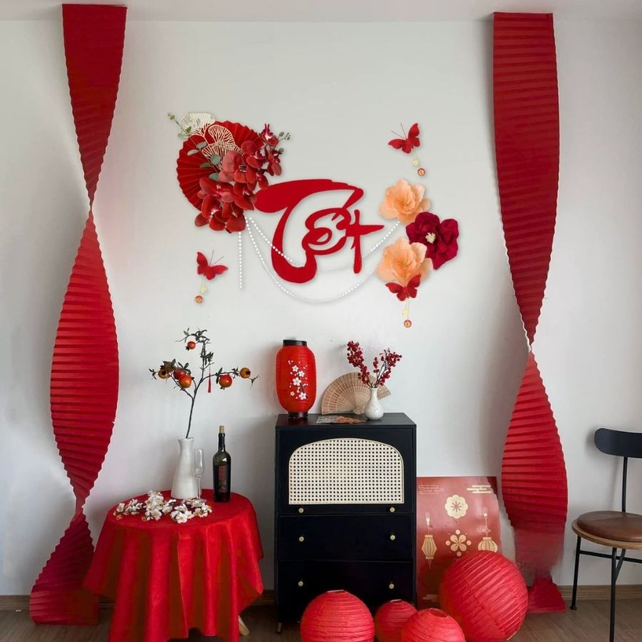 Trang trí tường nhà ngày Tết đơn giản mà ấn tượng với các phụ kiện hoa giấy và decal đỏ thắm rực rỡ.