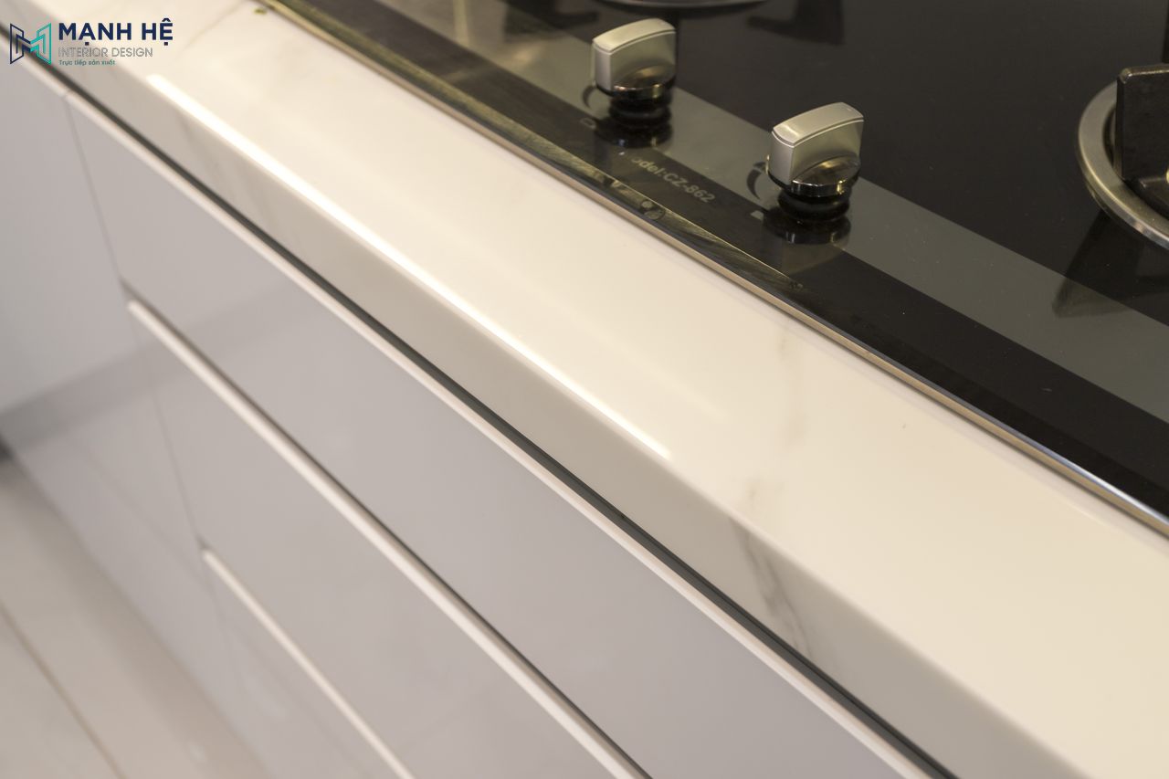 Mặt bếp ốp đá sáng bóng, thi công tỉ mỉ đến từng đường nét, với nhiều ngăn kéo tủ tiện nghi