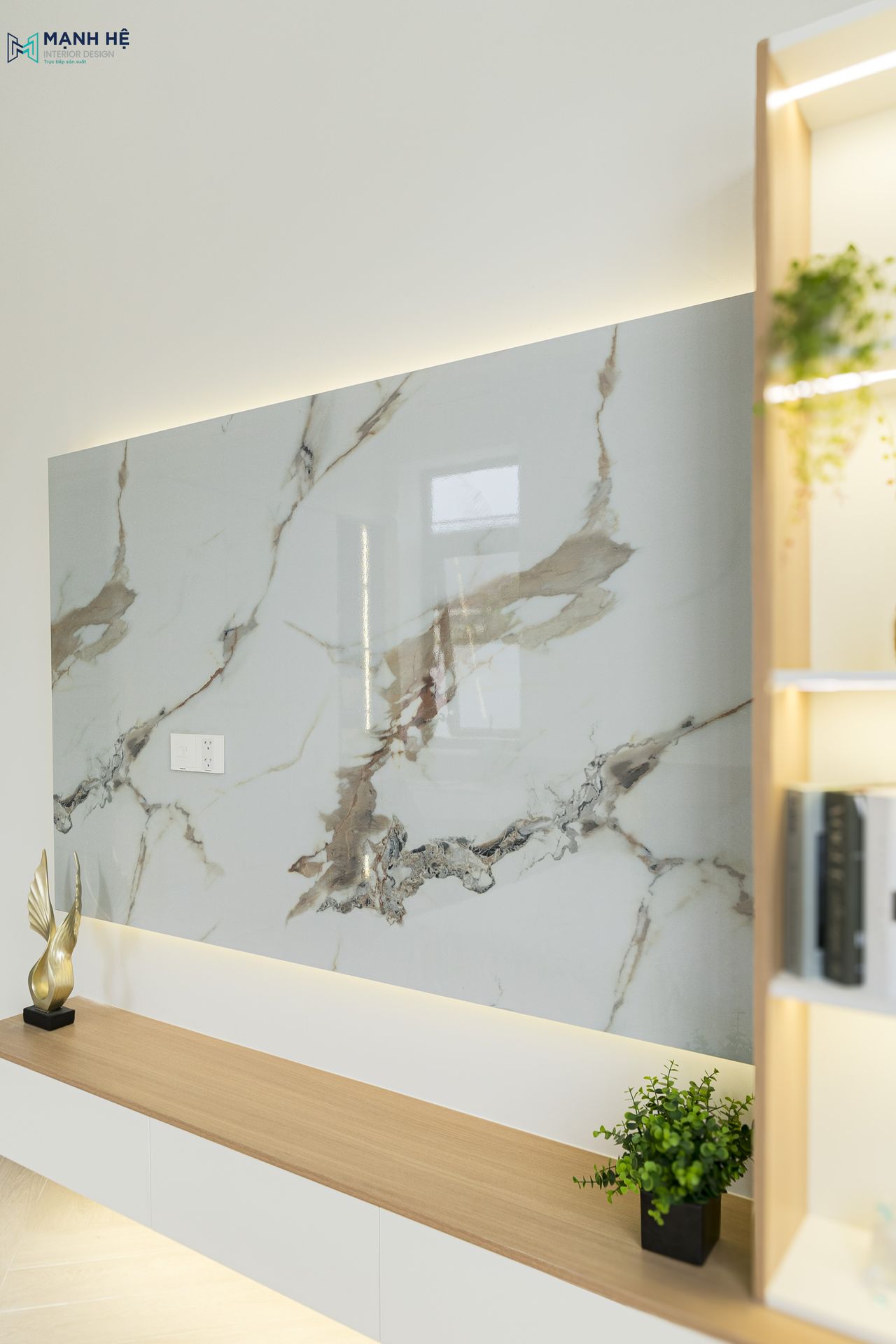 Thi công kệ tủ tivi treo tường với vách ốp tivi bằng loại đa nhân tạo có độ bền cao chống trầy xước, điểm nhấn là được gắn hệ đèn led phía sau vách