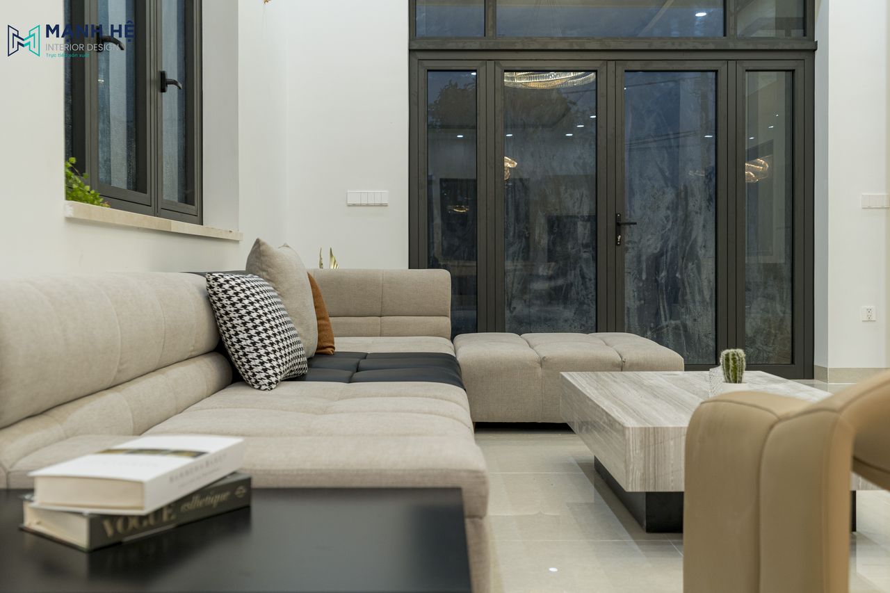 Bố trí ghế sofa chữ L bọc nhung tinh tế xám đậm nhấn đen, đường may cách điệu kết hợp cùng bàn trà gỗ sang trọng