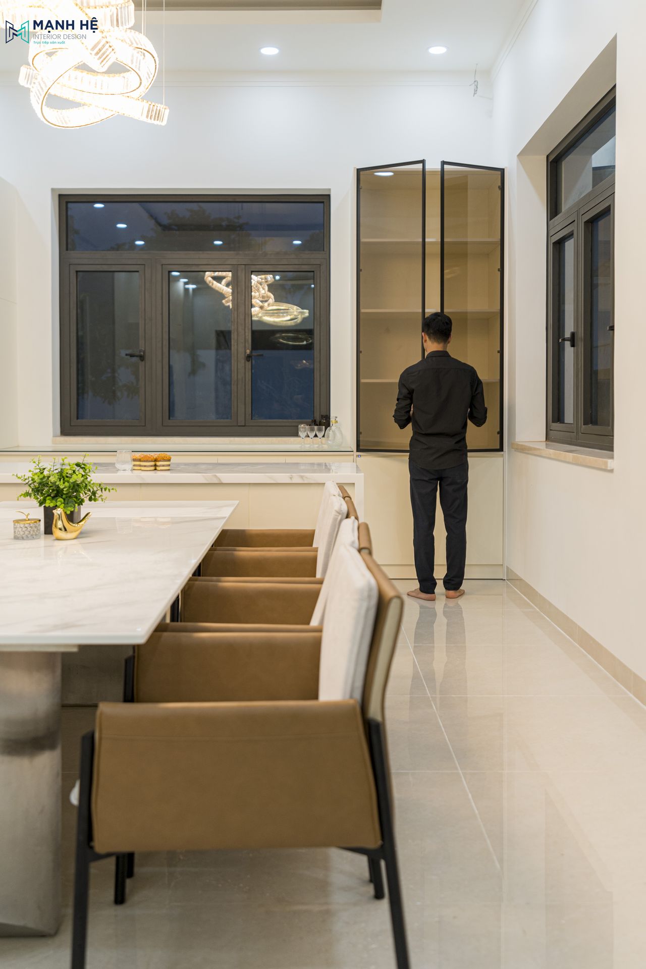 Thi công tủ rượu cánh kính tỉ mỹ, sắc nét tạo điểm thu hút cho căn bếp, kết hợp cùng đèn chùm bàn ăn độc đáo