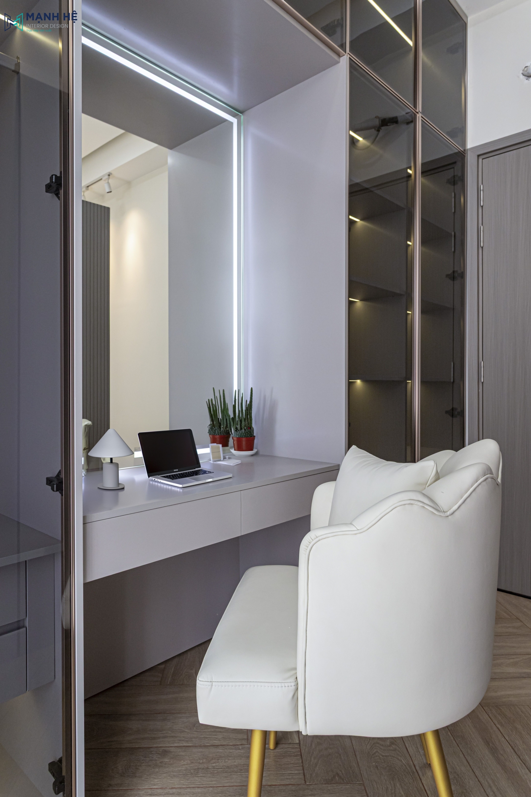 Bàn trang điểm với gương đèn LED và ghế bành nệm trắng, được tích hợp cùng tủ quần áo 
