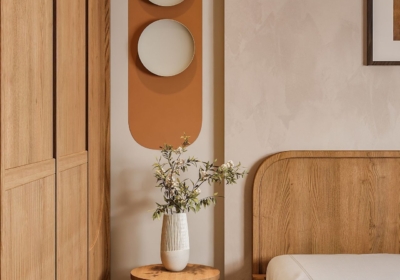 Kệ gỗ tròn xếp tầng bên đầu giường dùng để bày trí bình hoa và đồ decor trong phòng ngủ bé trai