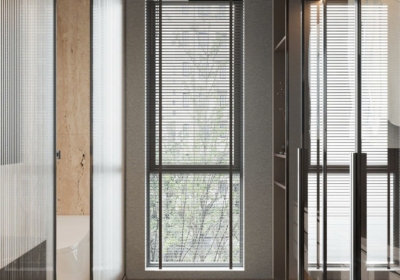 Tủ quần áo kính cường lực trong suốt viền nhôm đen, chiếu sáng bằng hệ đèn led ấm, phối cùng sàn gỗ xương cá và vách kính lấy sáng