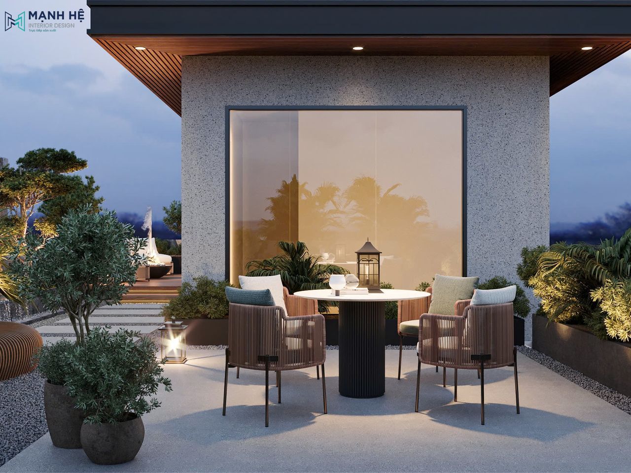 Góc bàn trà ngoài trời với ghế dây đan, bao quanh bởi mảng xanh đa dạng và khoảng trời rộng mở, tạo nên không gian thư giãn tinh tế và gần gũi