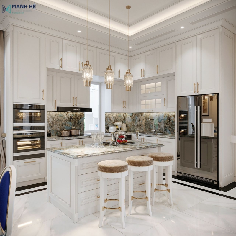 Cận cảnh đảo bếp biệt thự phong cách tân cổ điển, mặt đá vân xanh nhạt, ba ghế đôn lưng tròn bo mềm mại, tủ bếp kịch trần phối tay nắm ánh đồng nổi bật