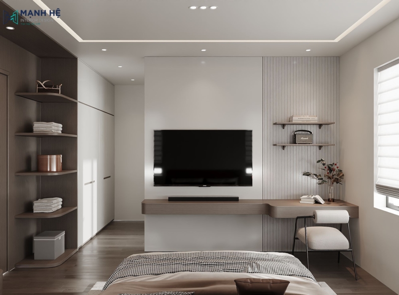 Kệ tivi kết hợp bàn làm việc liền tường gỗ nâu, ghế ngồi chân sắt bọc nệm trắng, bên trái là hệ kệ cong bo góc mềm mại