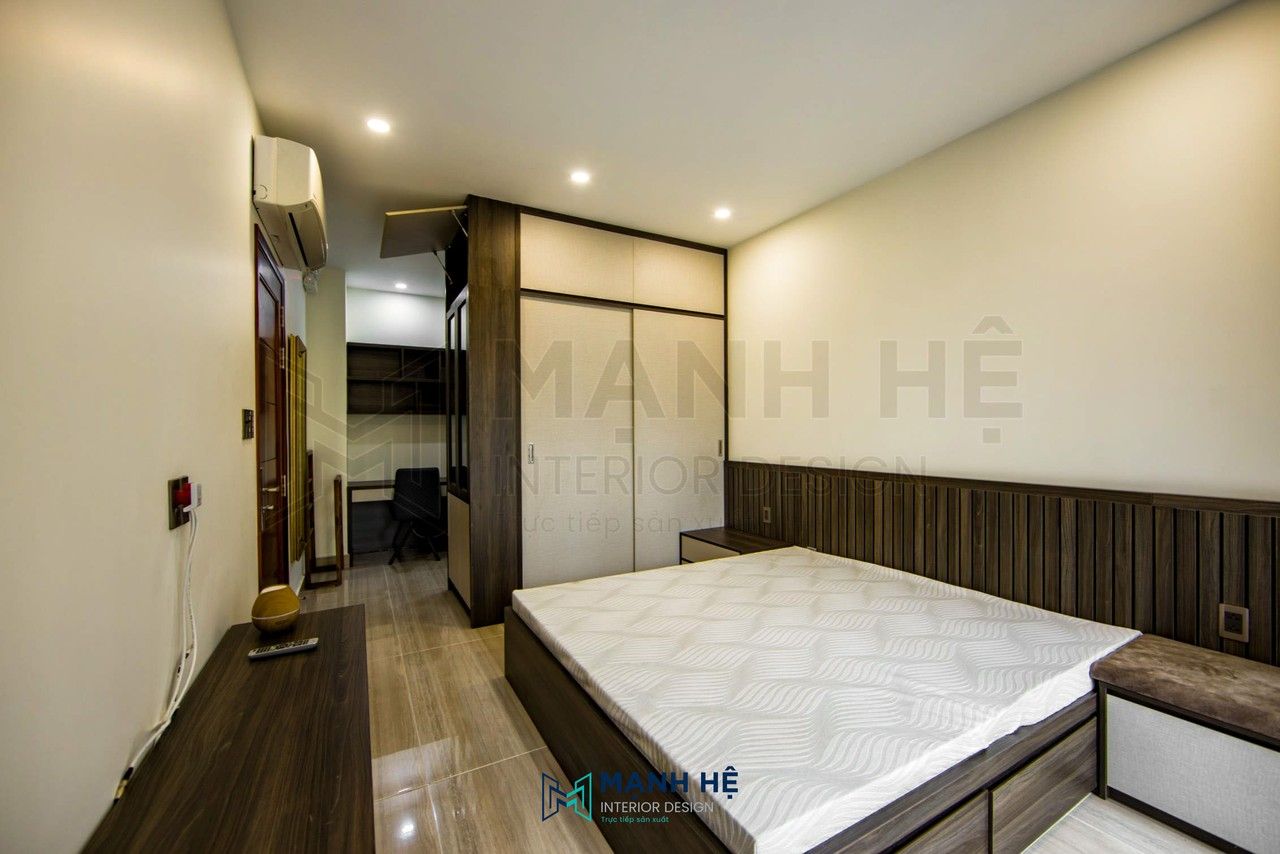 Tổng quan không gian phòng ngủ được bố trí thông minh với góc làm việc riêng tư, lấy hệ tủ quần áo làm vách ngăn