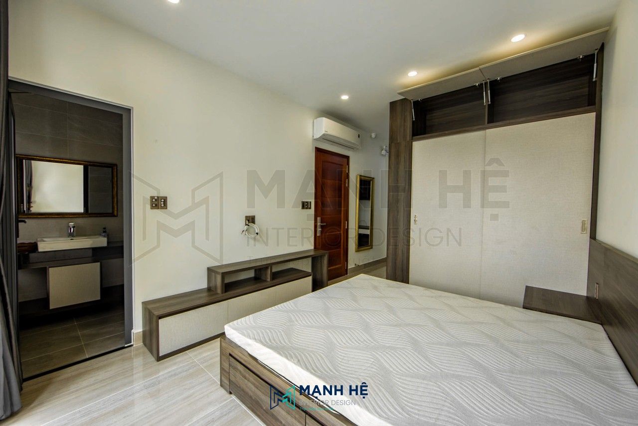 Thi công kệ tivi gỗ công nghiệp tối giản gồm ngăn hở và ngăn đóng, được bố trí sát tường tạo sự gọn gàng và đồng bộ với không gian phòng ngủ