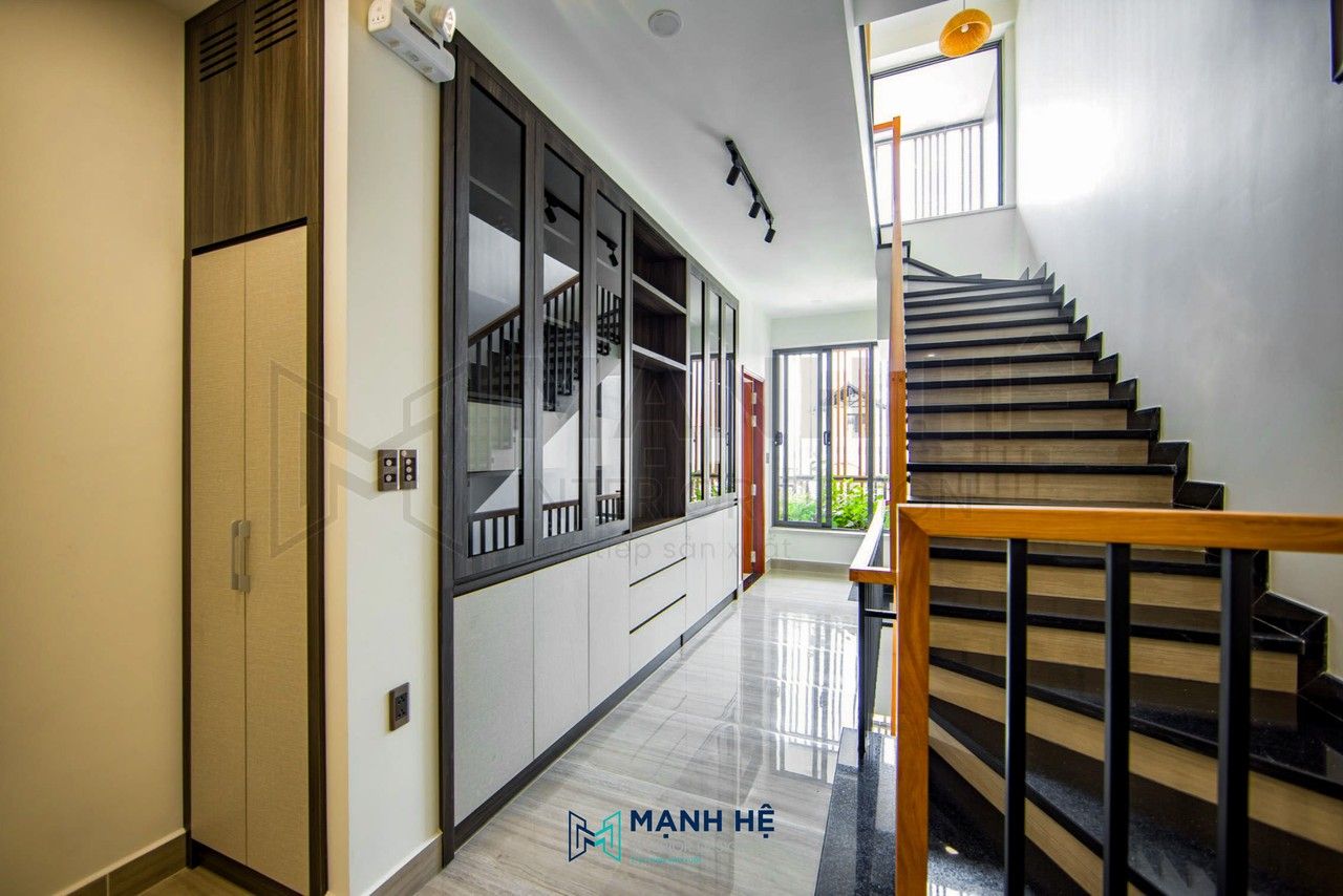 Không gian sảnh tầng 2 được thi công với hệ tủ trang trí kịch trần với gam màu nâu phối trắng chạy dọc suốt hành lang giúp tối ưu diện tích