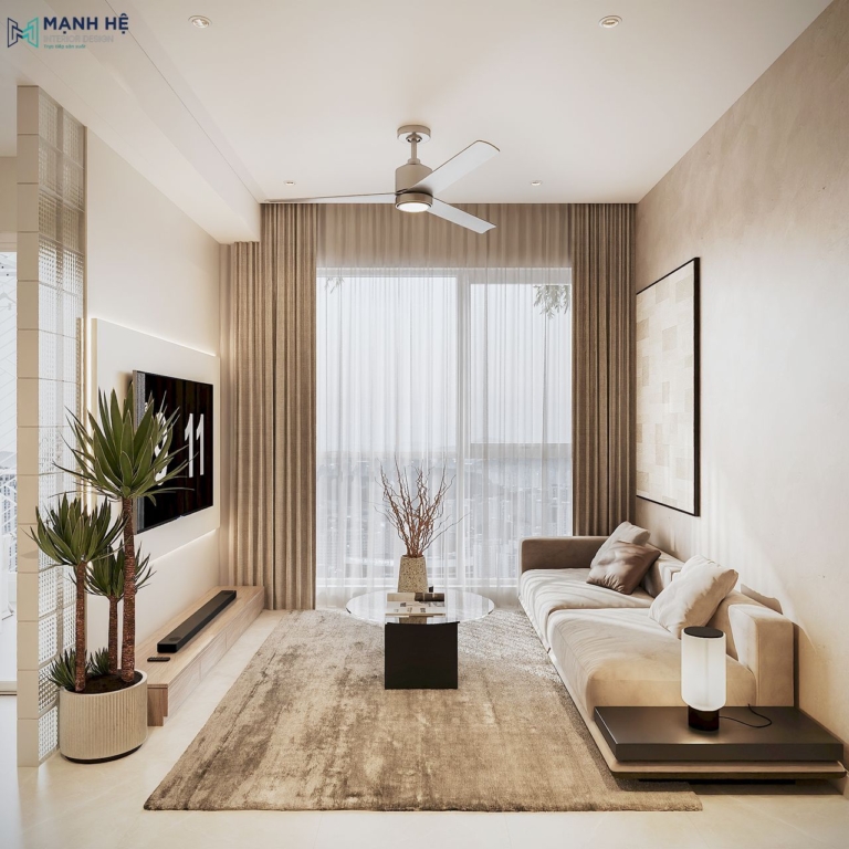 Phòng khách hiện đại, tinh tế với sofa be, bàn trà tròn và thảm trải sàn ấm áp, đón trọn ánh sáng tự nhiên từ cửa kính lớn kết hợp rèm voan nhẹ nhàng.