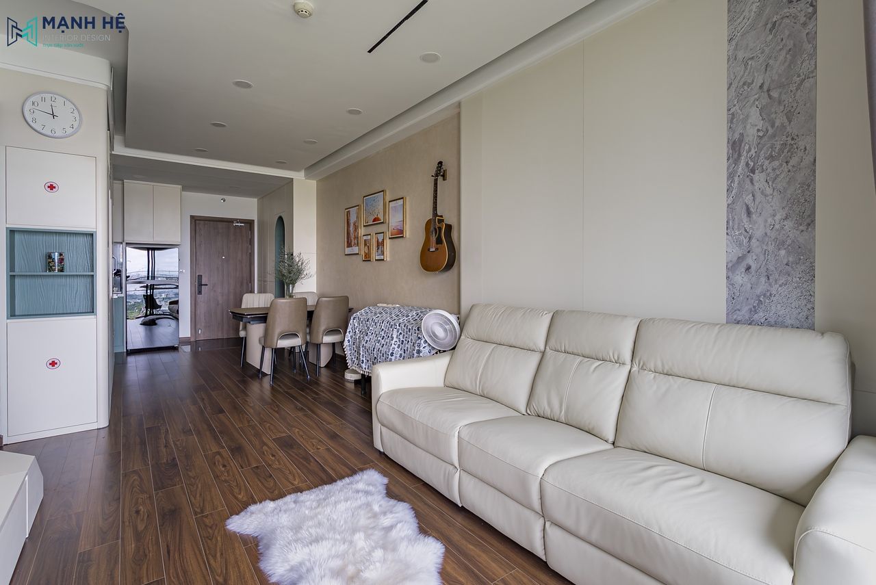 Phòng khách chung cư Akari hiện đại với sofa da sáng, sàn gỗ công nghiệp và bàn ăn liền kề