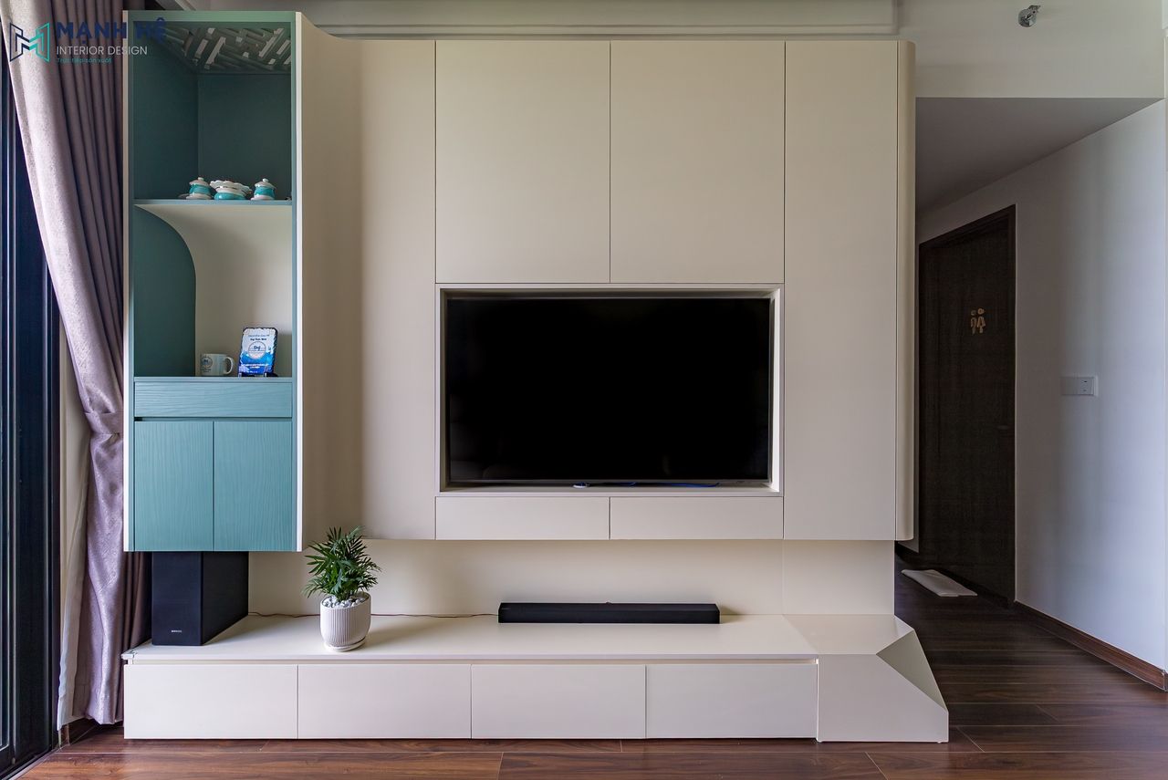 Kệ tivi gỗ công nghiệp MDF chống ẩm phủ Melamine với gam màu trắng phối xanh, lắp đặt liền mạch trong phòng khách chung cư Akari