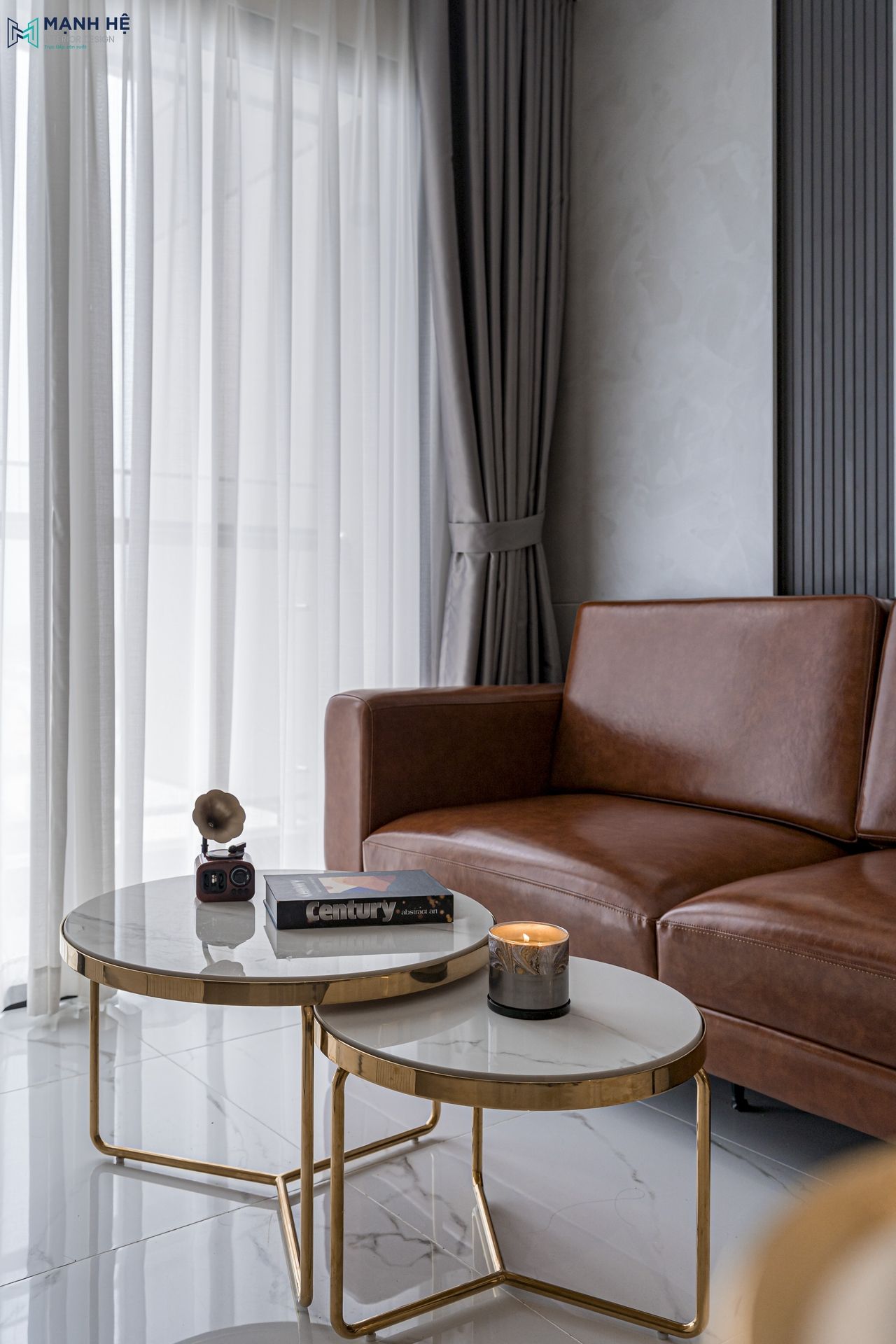 Bàn trà mặt đá vân mây, chân kim loại ánh vàng kết hợp ghế sofa bọc da nâu hiện đại