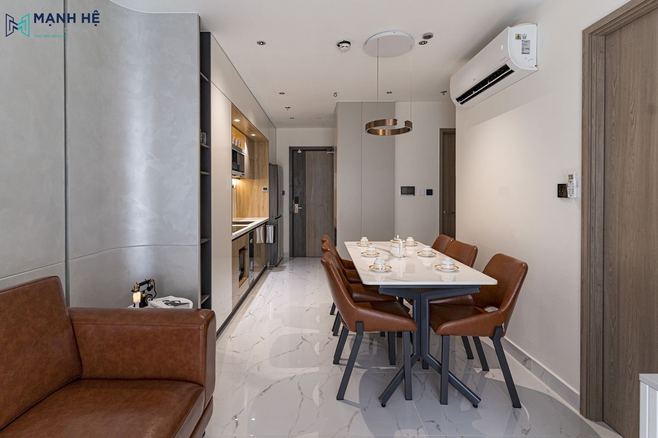 Thi công nội thất phòng khách và bếp liên thông tại căn hộ được bố trí mở với gam màu xám chủ đạo điểm xuyến sắc nâu ấm cúng