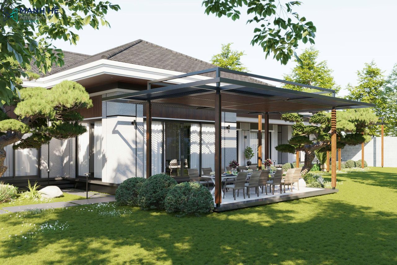 Khu vực ăn uống ngoài trời có mái che khung thép, bàn dài và ghế ăn cùng cảnh quan sân vườn xanh mát.