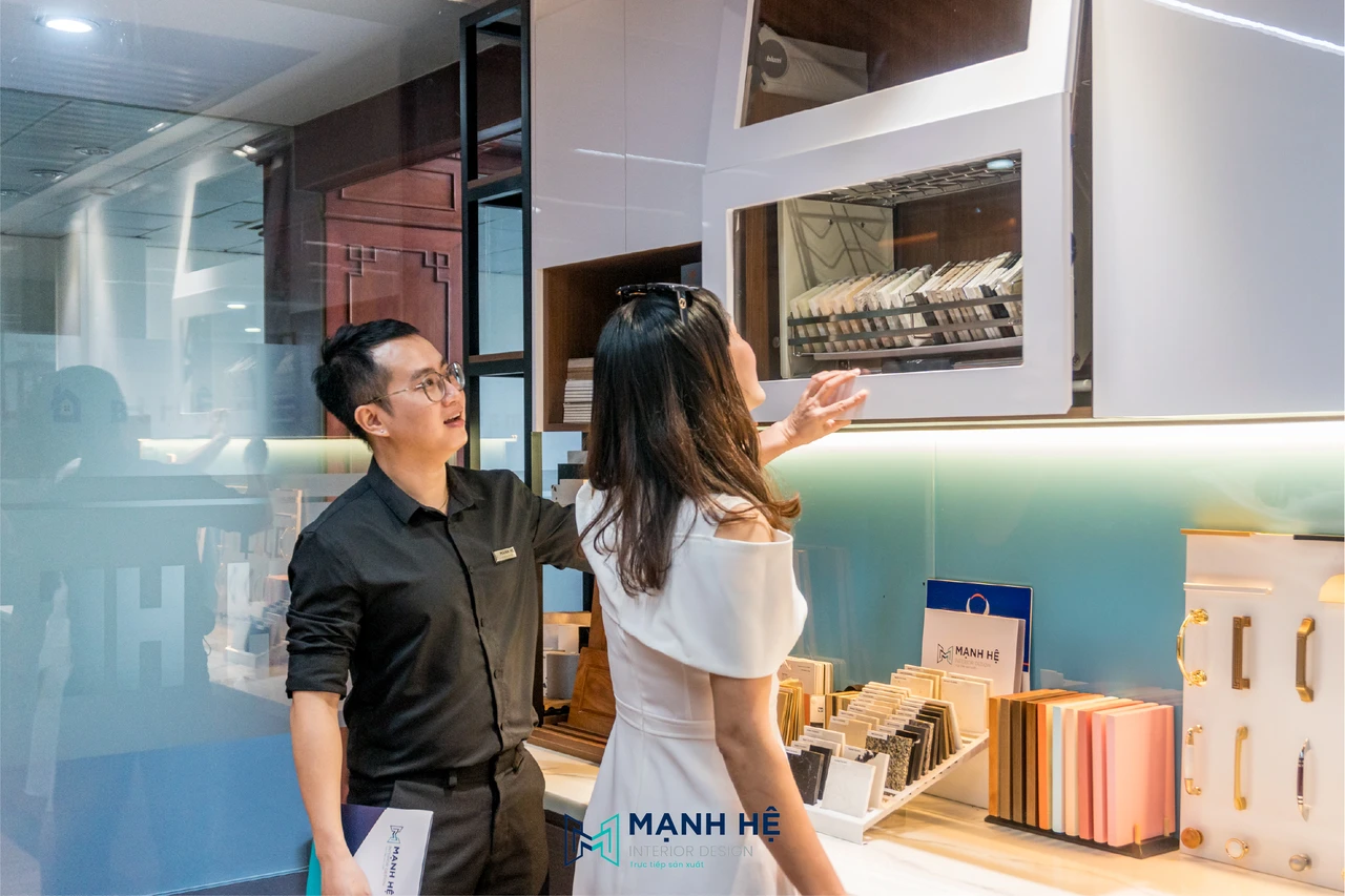 Chuyên viên Mạnh Hệ hỗ trợ khách hàng lựa chọn vật liệu và phụ kiện nội thất thực tế tại showroom