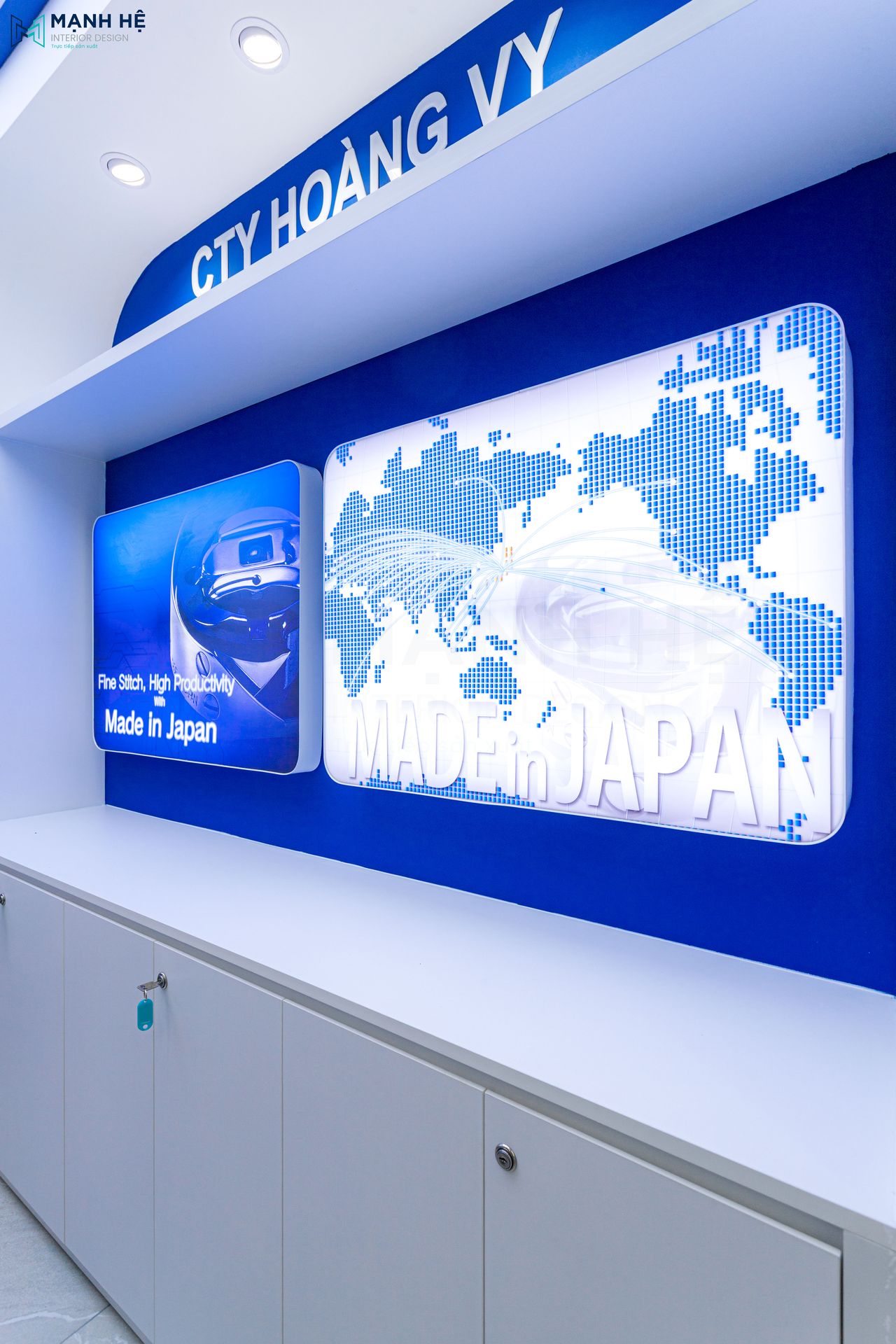 Hệ vách logo màu xanh thương hiệu kết hợp hộp đèn hắt sáng hiện đại, tạo điểm nhấn chuyên nghiệp cho văn phòng.