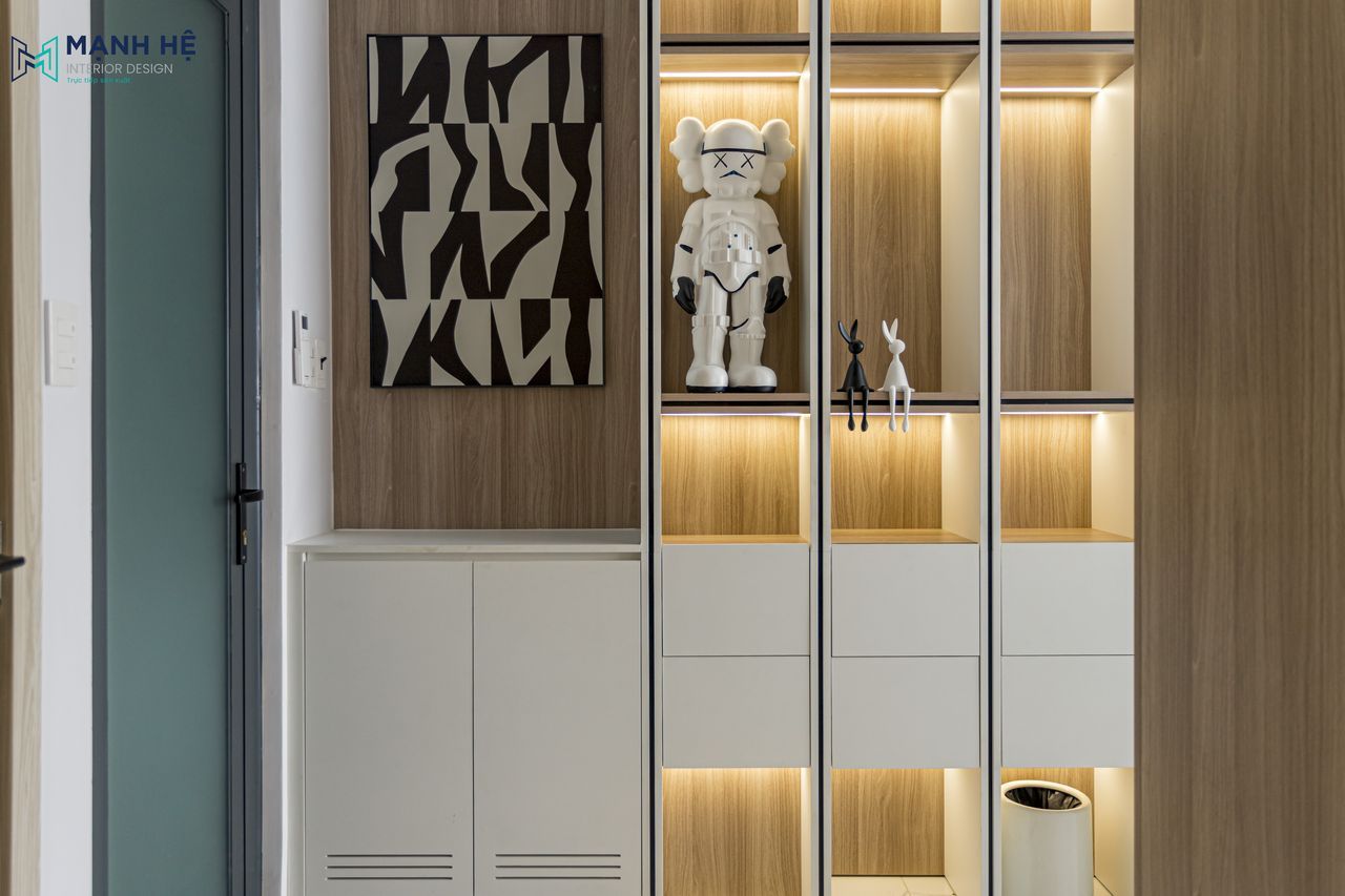 Hệ tủ trưng bày cánh kính tích hợp đèn LED nằm đối diện khu vực thay đồ, tạo điểm nhấn thu hút và hiện đại.