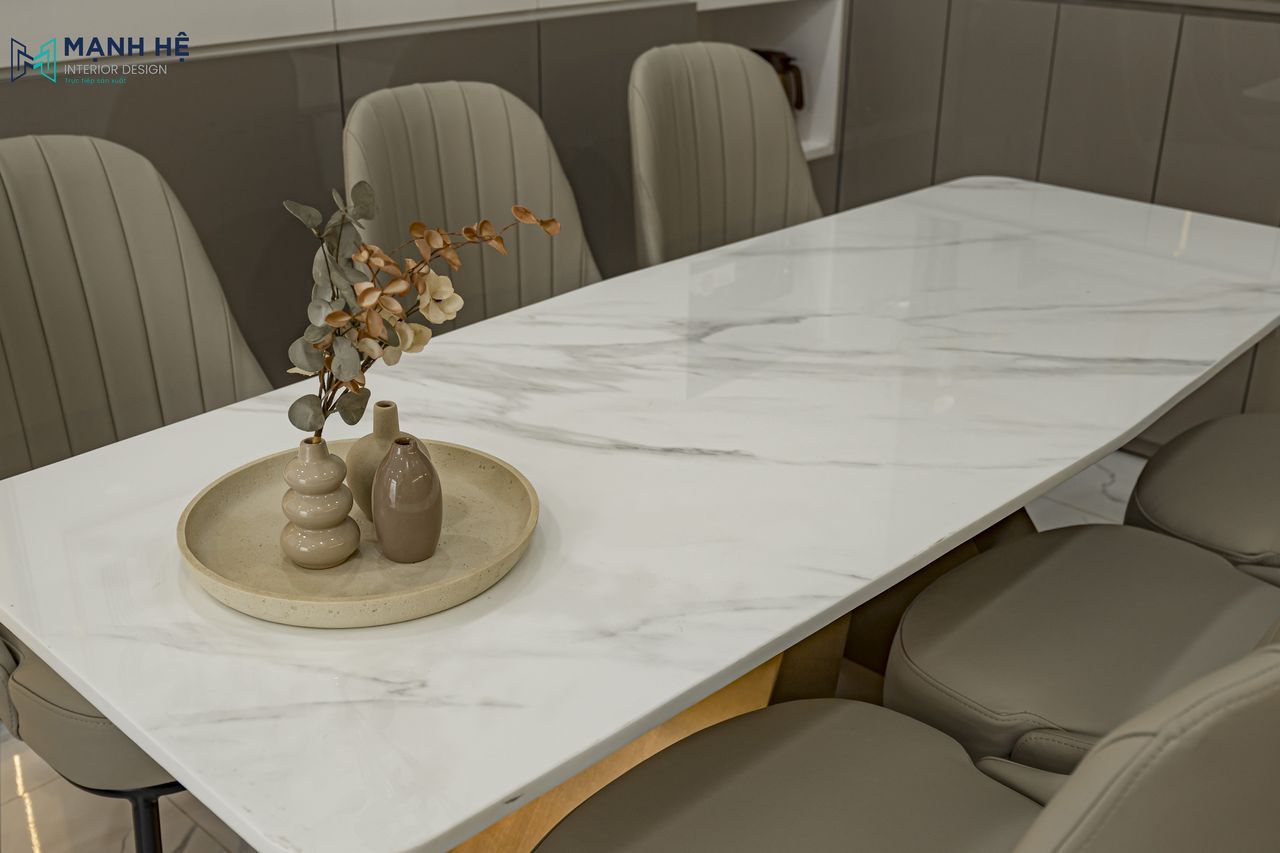Cận cảnh bộ bàn ăn mặt đá vân mây kết hợp ghế da êm ái được thi công tỉ mỉ, mang lại sự thoải mái cho những bữa cơm gia đình.