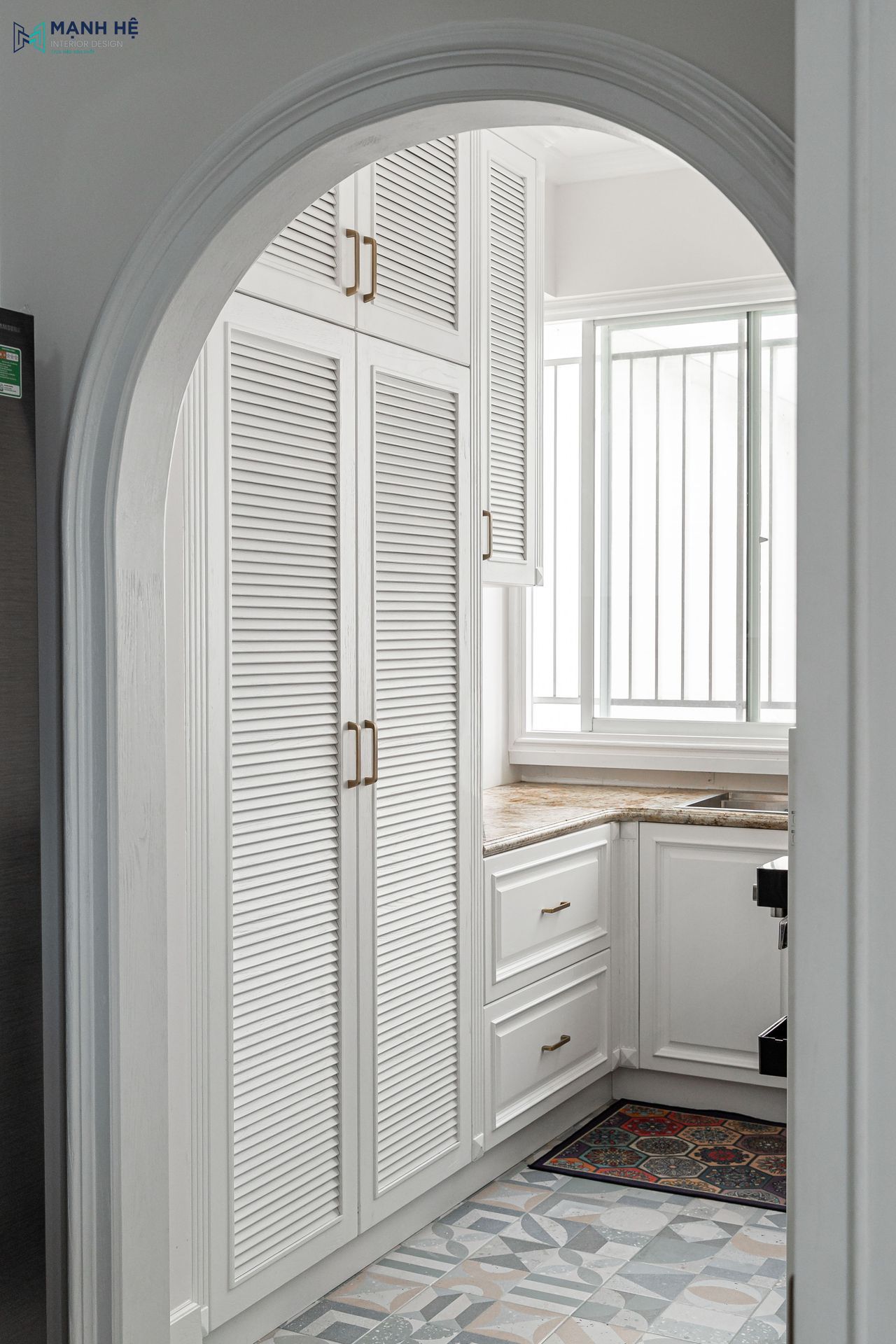 Khung cửa vòm được xử lý phào chỉ sắc nét, tạo sự chuyển tiếp nhẹ nhàng và giúp đón trọn nguồn sáng tự nhiên cho gian bếp luôn thông thoáng.