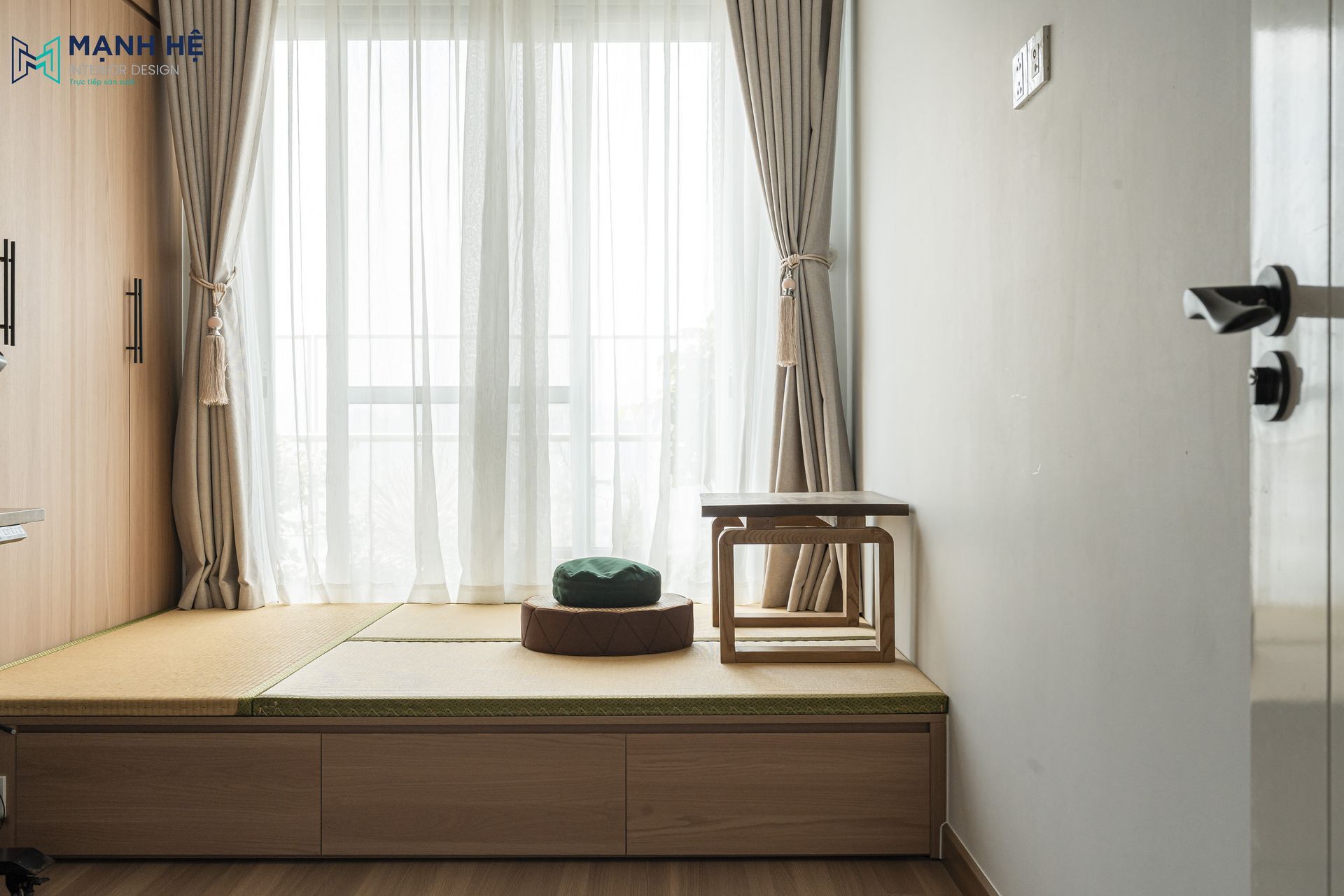 Góc làm việc kết hợp bục gỗ tích hợp ngăn kéo lưu trữ, tận dụng ánh sáng tự nhiên từ cửa sổ giúp tạo không gian thư giãn và đọc sách lý tưởng.