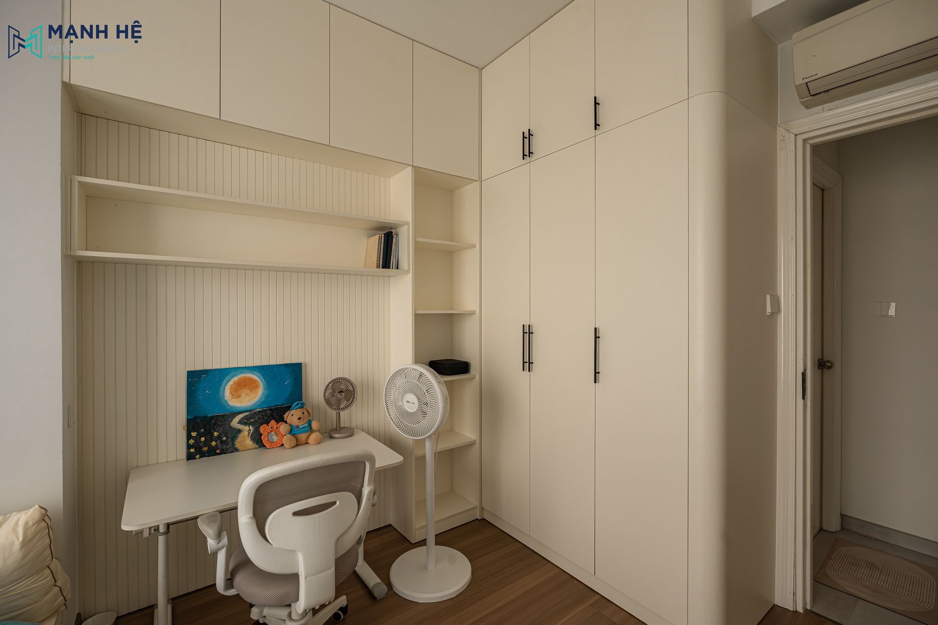 Hệ tủ quần áo liền bàn học được hoàn thiện sắc nét với chi tiết bo cong góc tủ, đảm bảo tính gọn gàng và công năng trong không gian nhỏ.