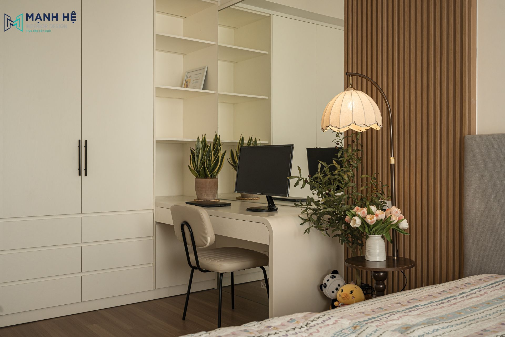 Bàn làm việc được thi công liền khối với hệ tủ quần áo và kệ sách, tận dụng tối đa góc chết để tạo khu vực làm việc tiện nghi.