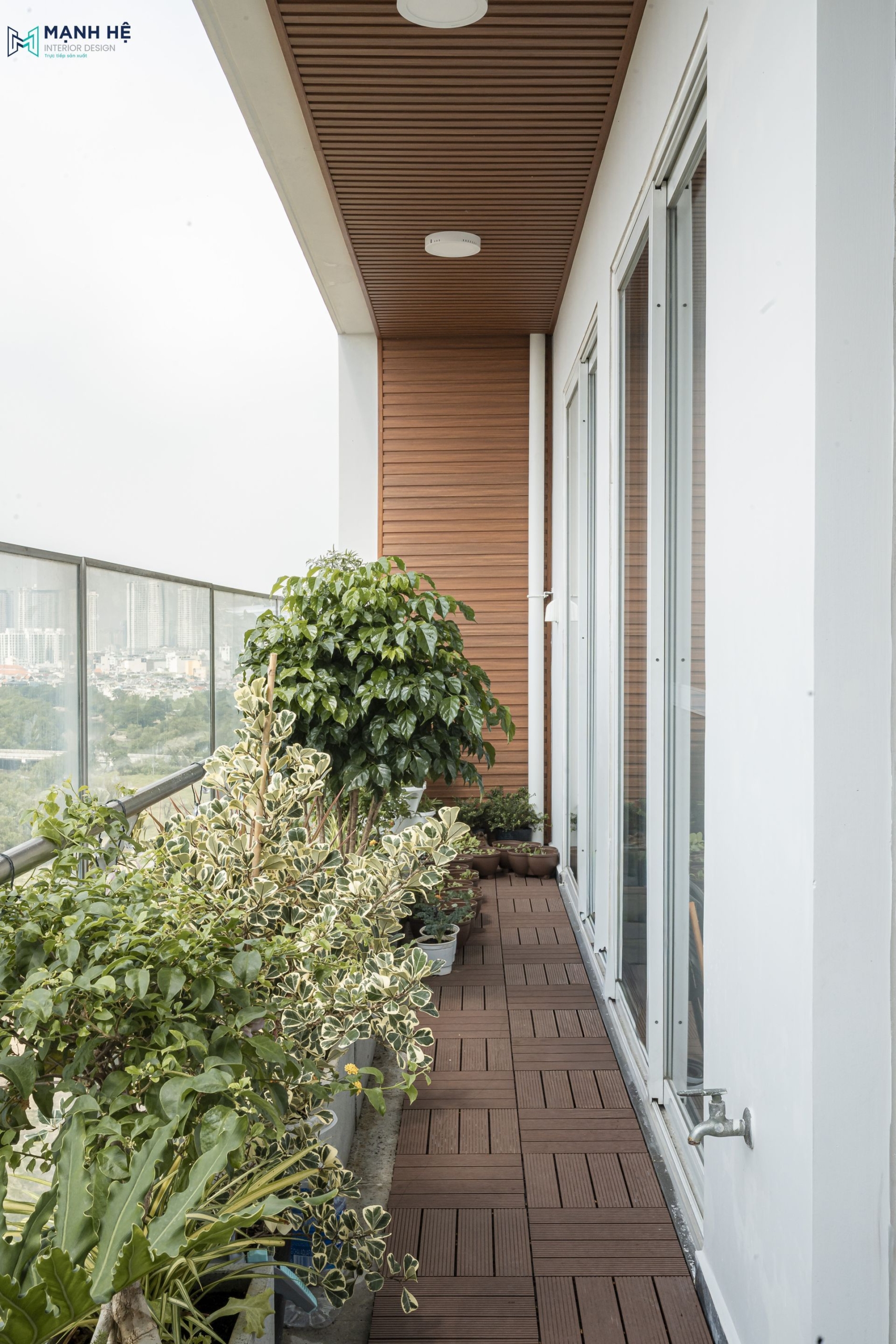 Khu vực ban công được làm mới bằng sàn gỗ nhựa và vách ốp lam đồng bộ, mở ra không gian thư giãn xanh mát và bền bỉ trước mọi điều kiện thời tiết.