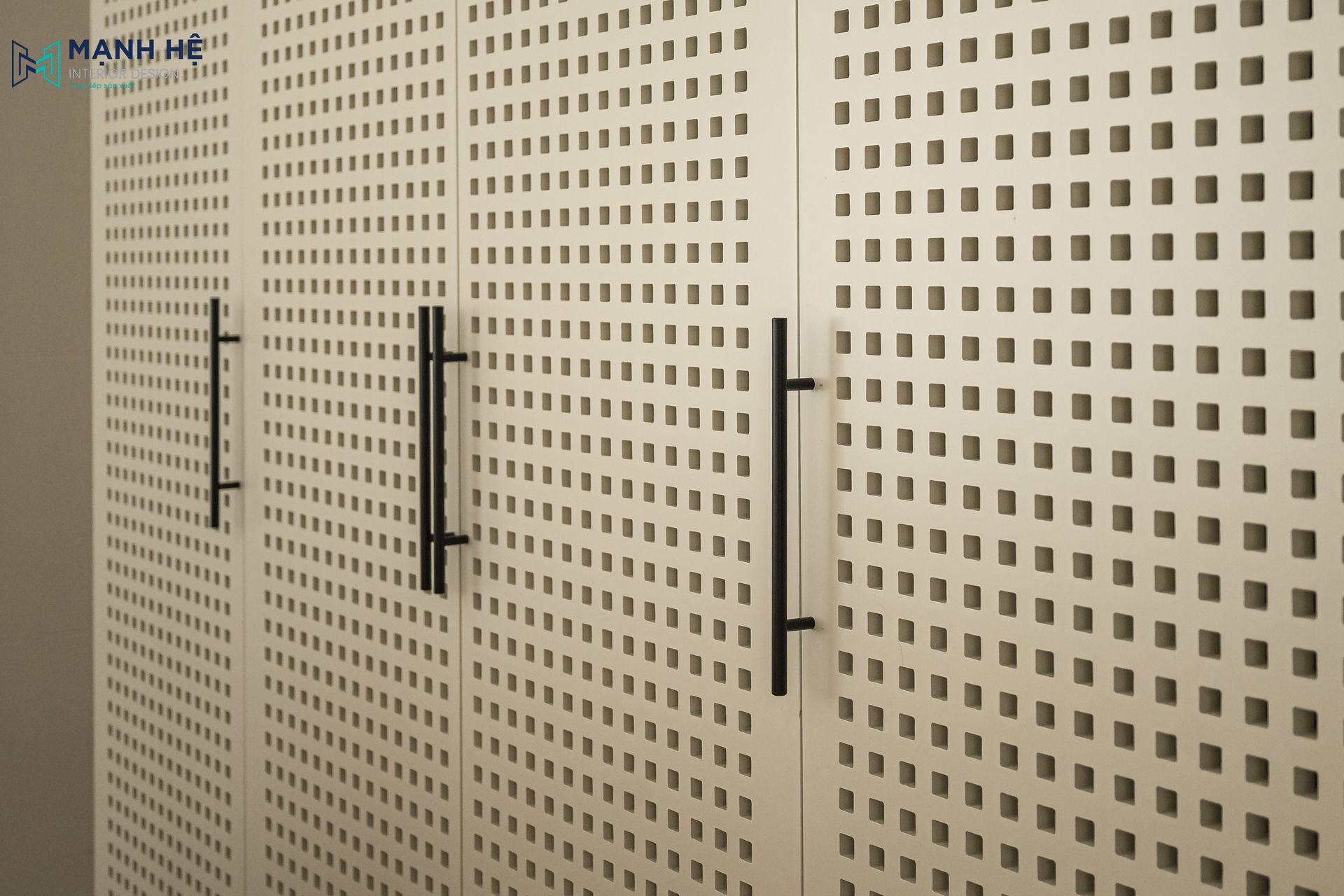 Cận cảnh hệ cánh tủ lỗ tổ ong được thi công tỉ mỉ phối cùng tay nắm đũa đen hiện đại, tạo nên điểm nhấn thẩm mỹ độc đáo cho hệ tủ kho.